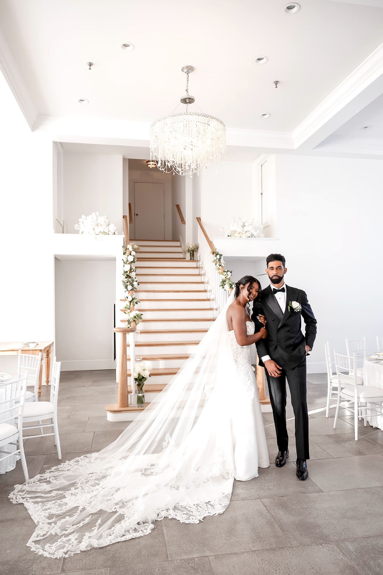 Bride and groom on a floral-draped grand staircase at a Boston wedding venue